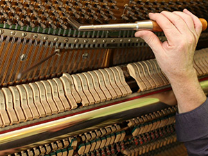 man tuning piano